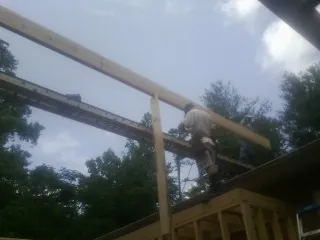 Carpenter setting a ridge beam over a new addition frame — Ice Dam Removal by Roofing Brothers in Chatham